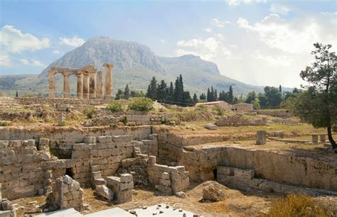 The stone ruins of the ancient city of Corinth with a mountain in the background.