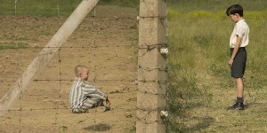 A child sitting behind a barbed wire fence.