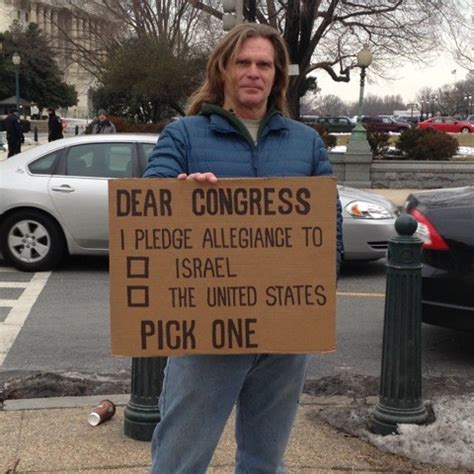 A protestor with a cardboard sign telling congress to decide on who they pledge alliegance to; America or Israel.
