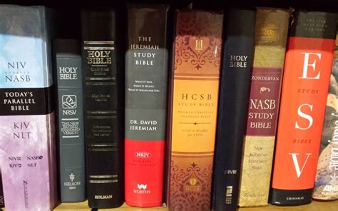 A stack of different bibles standing on a shelf.