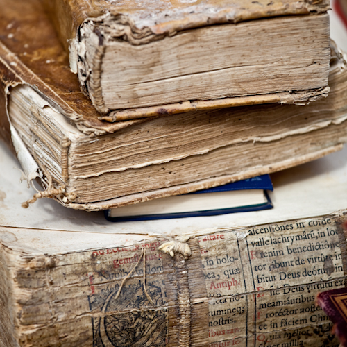 Old books sitting on a white table.