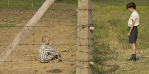 A child sitting behind a barbed wire fence.