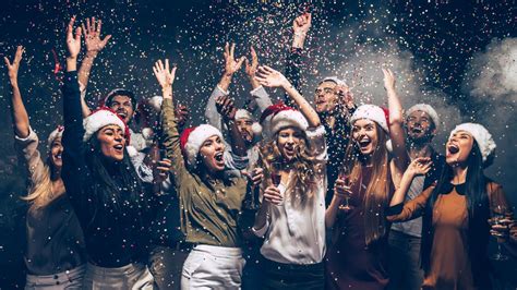 A group of people in christmas hats celebrating.